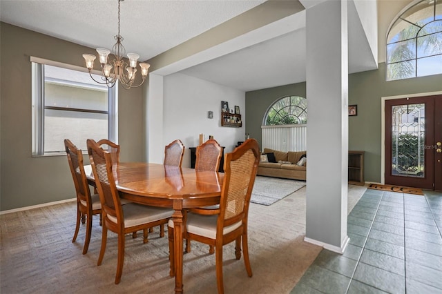 dining room featuring carpet floors, a notable chandelier, and a textured ceiling