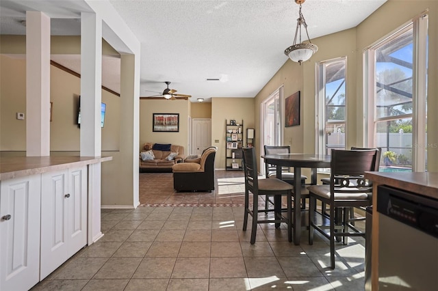 dining space featuring ceiling fan, tile patterned floors, and a textured ceiling