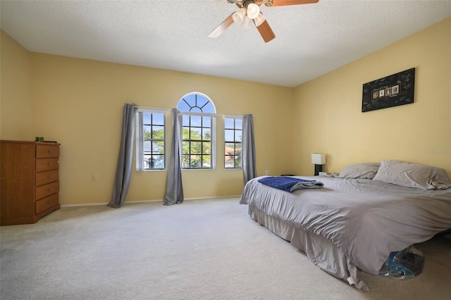 bedroom with a textured ceiling, light carpet, and ceiling fan