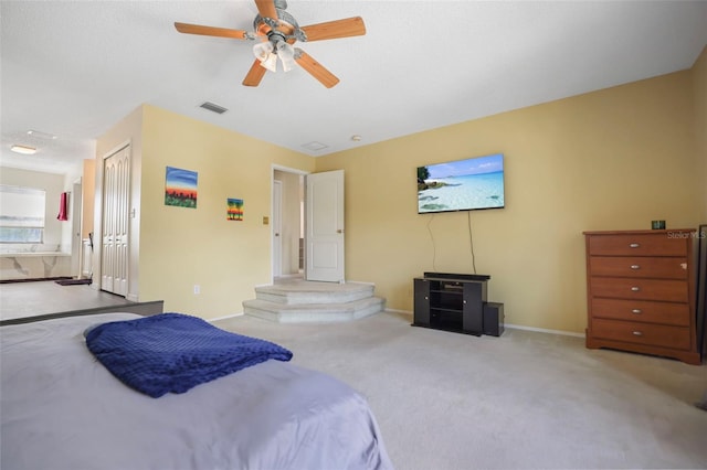 bedroom featuring a closet, a textured ceiling, ceiling fan, ensuite bath, and light colored carpet