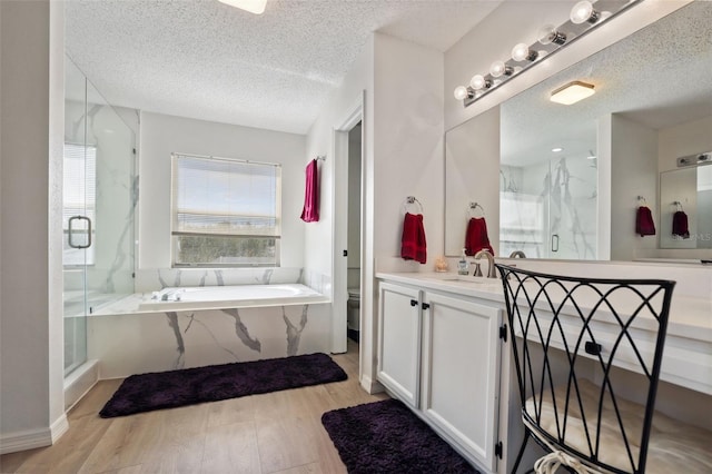 bathroom featuring vanity, shower with separate bathtub, a textured ceiling, and hardwood / wood-style flooring