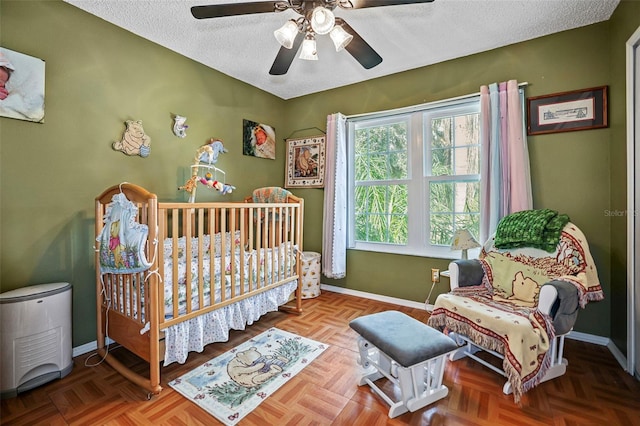 bedroom featuring ceiling fan, a textured ceiling, and parquet floors