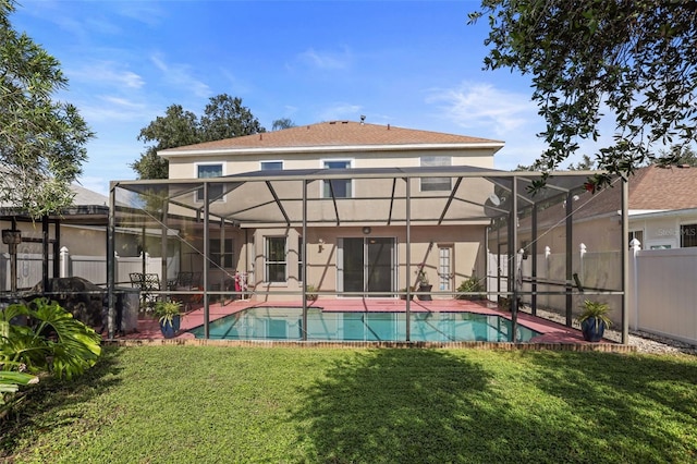 back of property featuring a fenced in pool, glass enclosure, a patio, and a lawn