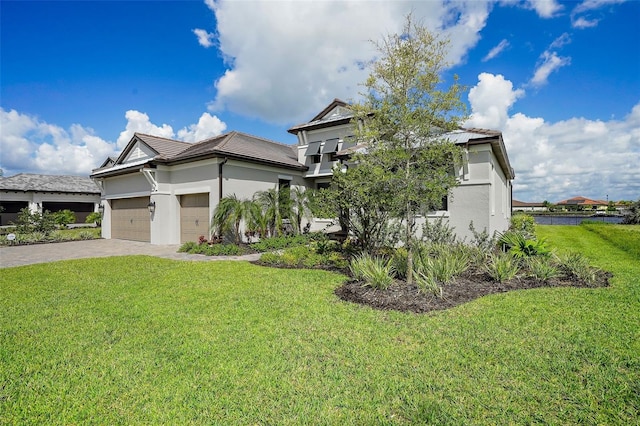 view of front of home with a front yard and a garage