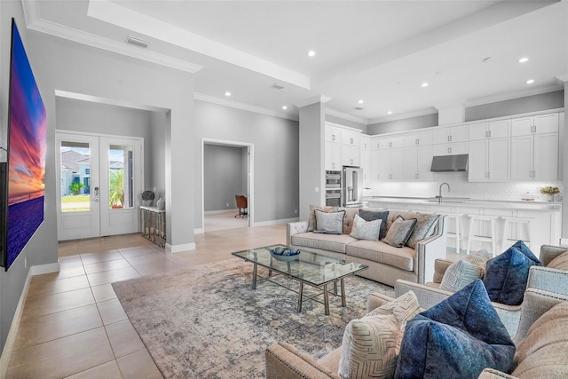 living room featuring sink, light tile patterned flooring, french doors, and ornamental molding