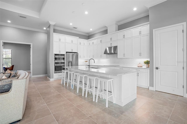 kitchen featuring a kitchen island with sink, sink, white cabinets, and appliances with stainless steel finishes