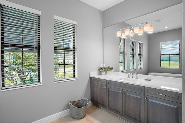 bathroom featuring tile patterned flooring, vanity, and a healthy amount of sunlight