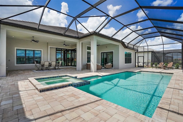 view of pool with glass enclosure, ceiling fan, an in ground hot tub, and a patio