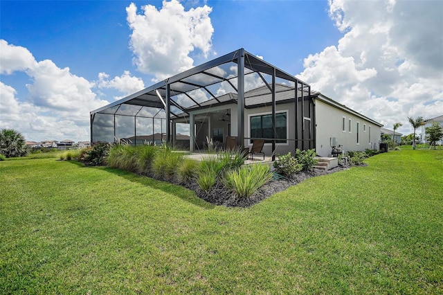 back of house with a yard, glass enclosure, and ceiling fan