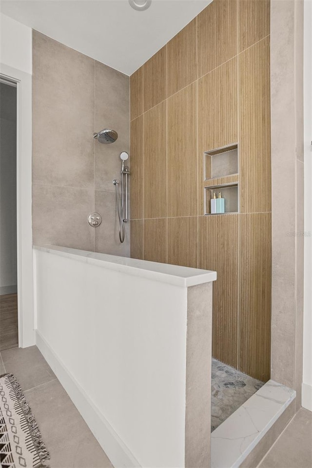 bathroom with tile patterned floors and tiled shower