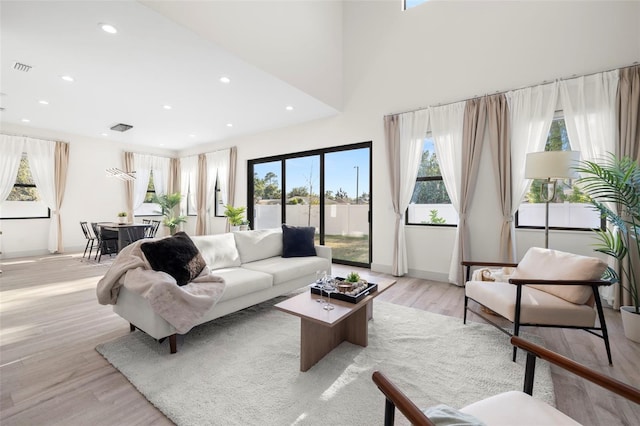 living room featuring plenty of natural light, light wood-style flooring, baseboards, and recessed lighting