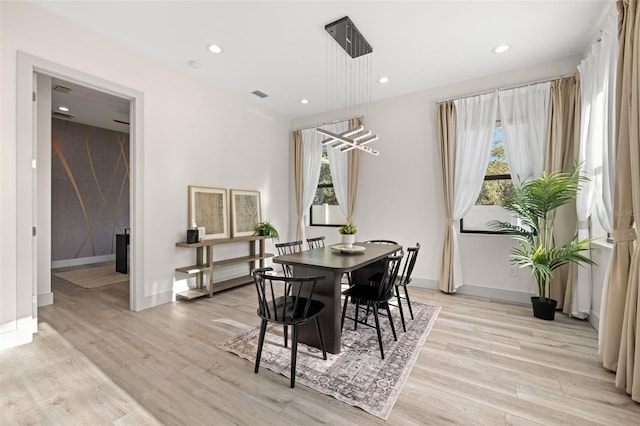 dining space with visible vents, plenty of natural light, baseboards, and light wood-style floors