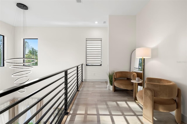 sitting room with baseboards, light wood-type flooring, and recessed lighting