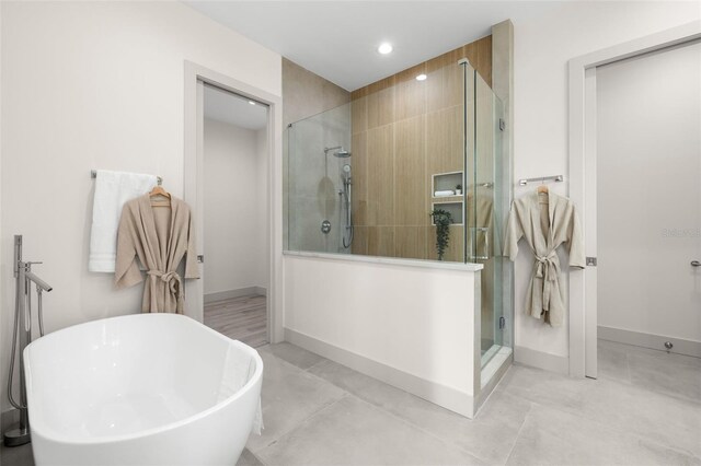 full bathroom with baseboards, a soaking tub, a stall shower, and recessed lighting