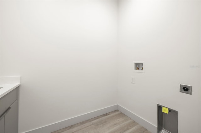 laundry room featuring hookup for an electric dryer, light wood-style floors, baseboards, cabinet space, and washer hookup
