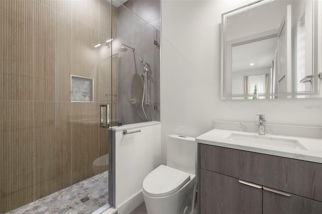 bathroom featuring toilet, vanity, and a stall shower