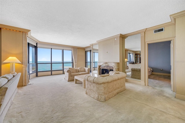 carpeted living room featuring ornamental molding, a water view, and a textured ceiling