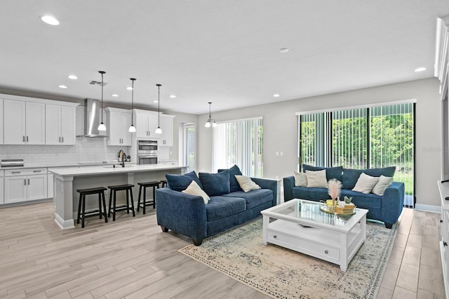 living room featuring light wood-type flooring and sink