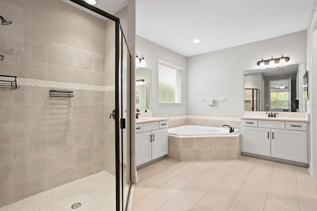 bathroom with vanity, shower with separate bathtub, and a wealth of natural light