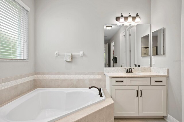 bathroom featuring vanity and a relaxing tiled tub