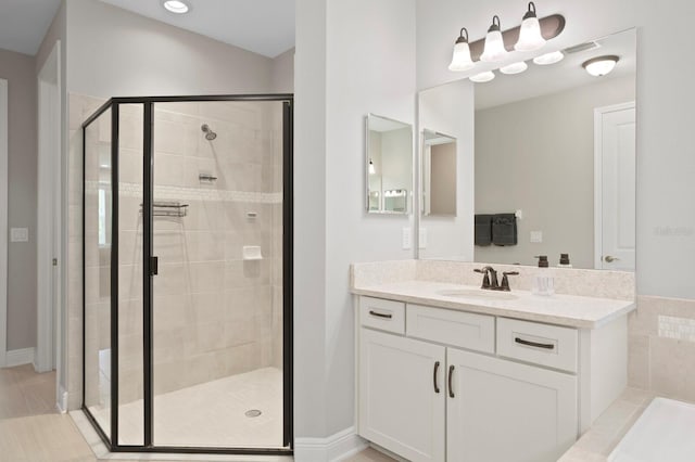 bathroom featuring vanity and a shower with door