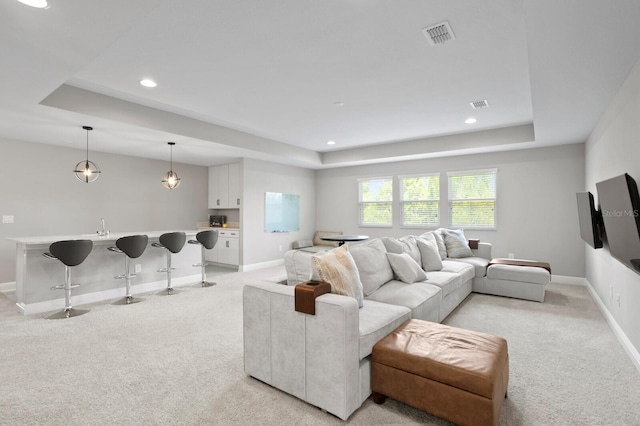 carpeted living room with a raised ceiling