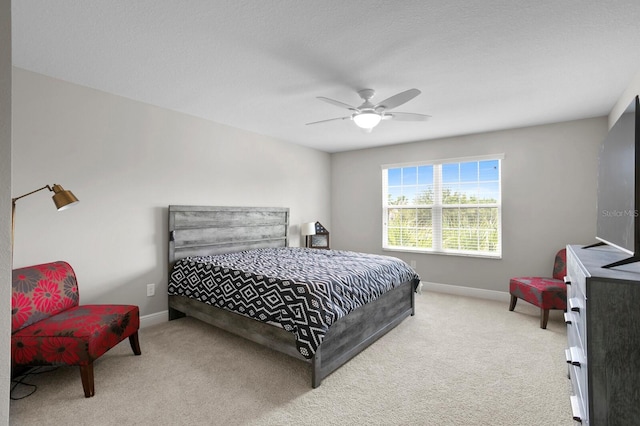 bedroom with ceiling fan, carpet floors, and a textured ceiling