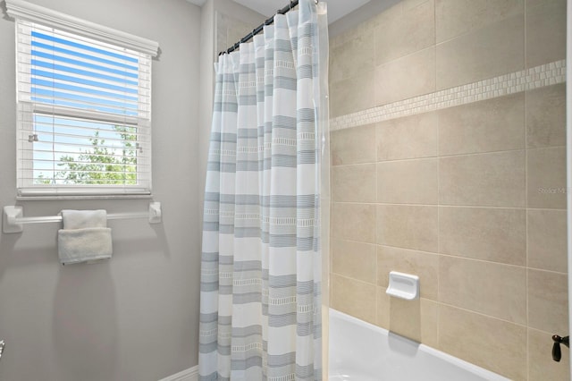 bathroom with shower / bathtub combination with curtain and plenty of natural light