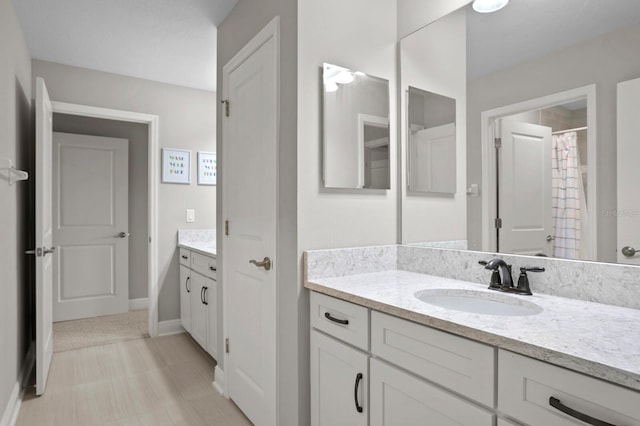 bathroom featuring walk in shower and vanity