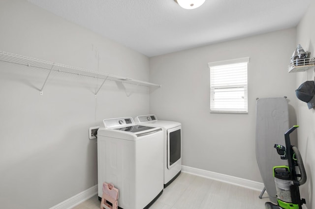 clothes washing area with washer and clothes dryer