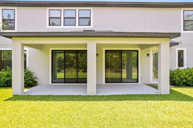 rear view of house with a lawn and a patio area