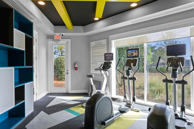 workout room with a tray ceiling