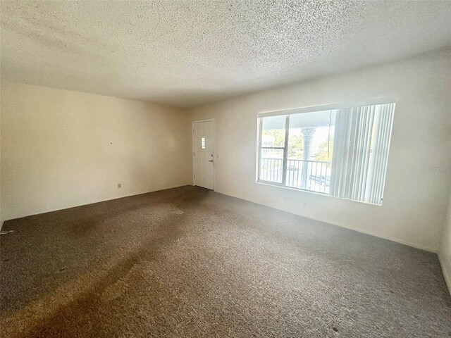 unfurnished room with a textured ceiling