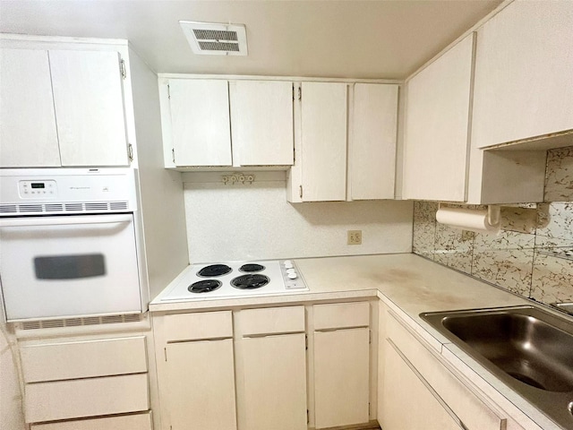 kitchen with sink, white appliances, and tasteful backsplash