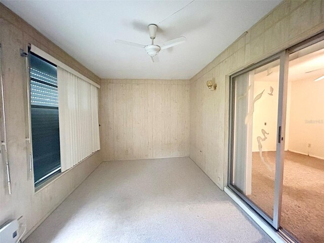 unfurnished sunroom featuring ceiling fan