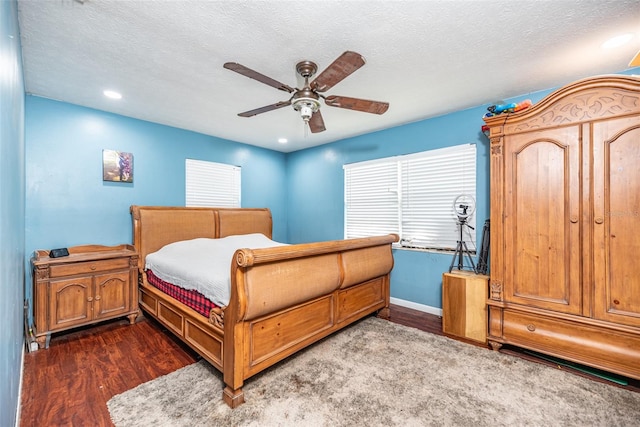 bedroom featuring ceiling fan, dark wood-type flooring, and a textured ceiling