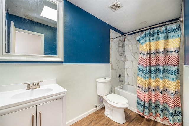 full bathroom featuring shower / tub combo with curtain, hardwood / wood-style flooring, vanity, a textured ceiling, and toilet