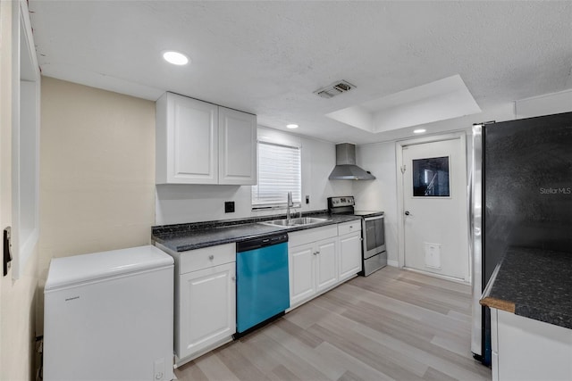 kitchen featuring white cabinetry, appliances with stainless steel finishes, sink, and wall chimney range hood