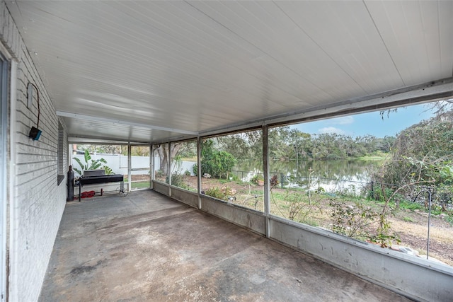 unfurnished sunroom featuring a water view