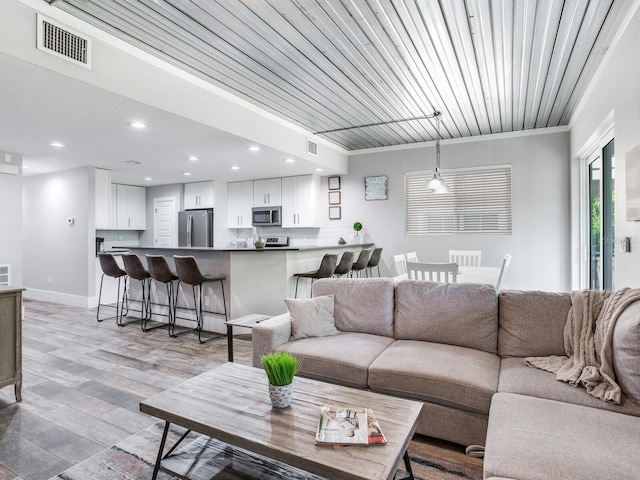 living room with light hardwood / wood-style flooring and crown molding