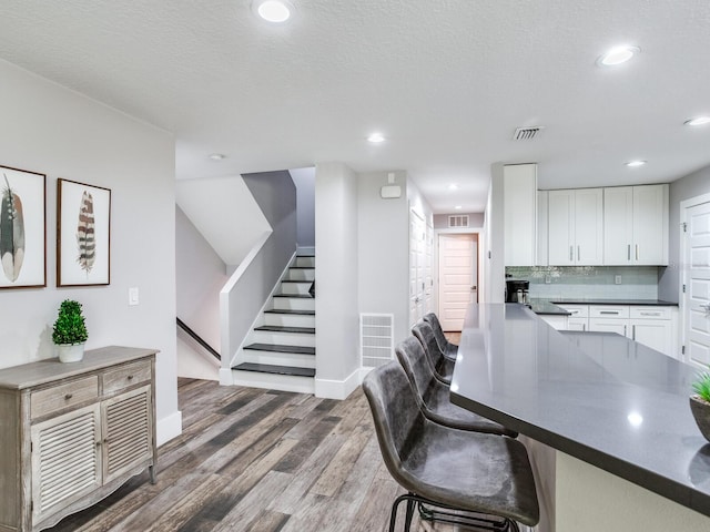 interior space featuring a textured ceiling and dark hardwood / wood-style floors