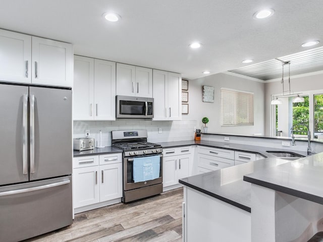 kitchen with white cabinetry, pendant lighting, and stainless steel appliances