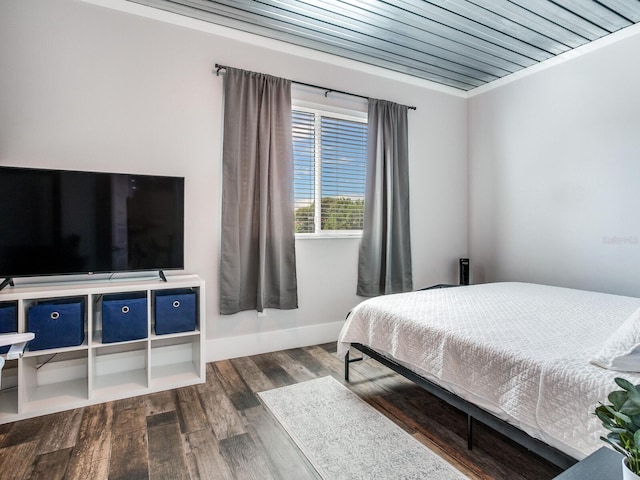 bedroom with crown molding and dark wood-type flooring