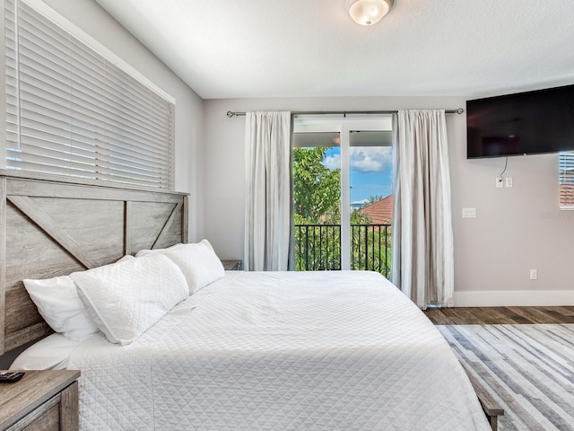 bedroom with wood-type flooring and access to outside