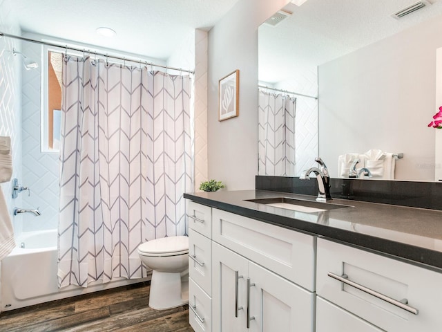 full bathroom with vanity, shower / bath combination with curtain, a textured ceiling, wood-type flooring, and toilet