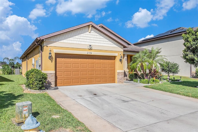 view of front of home with a front yard and a garage