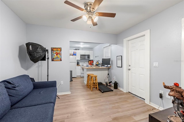 living room featuring ceiling fan and light hardwood / wood-style floors