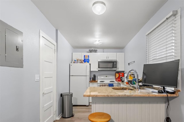 kitchen with white cabinetry, white appliances, kitchen peninsula, and electric panel