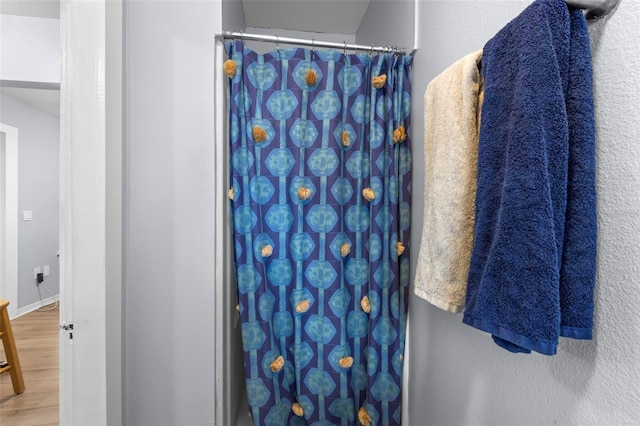 bathroom with hardwood / wood-style floors and curtained shower