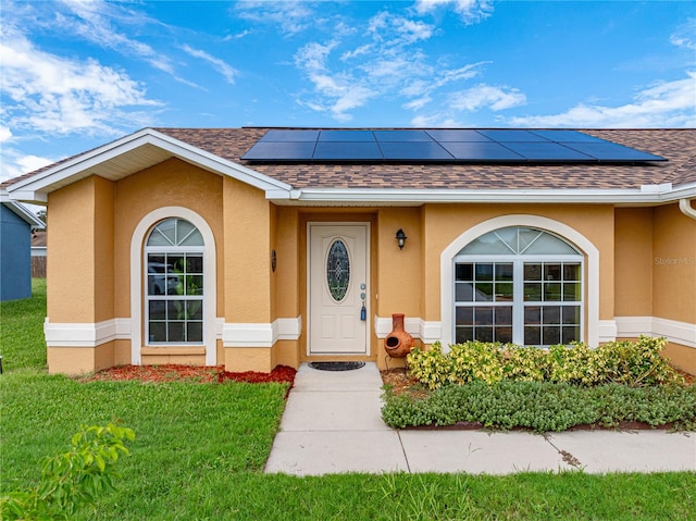 property entrance featuring solar panels and a yard